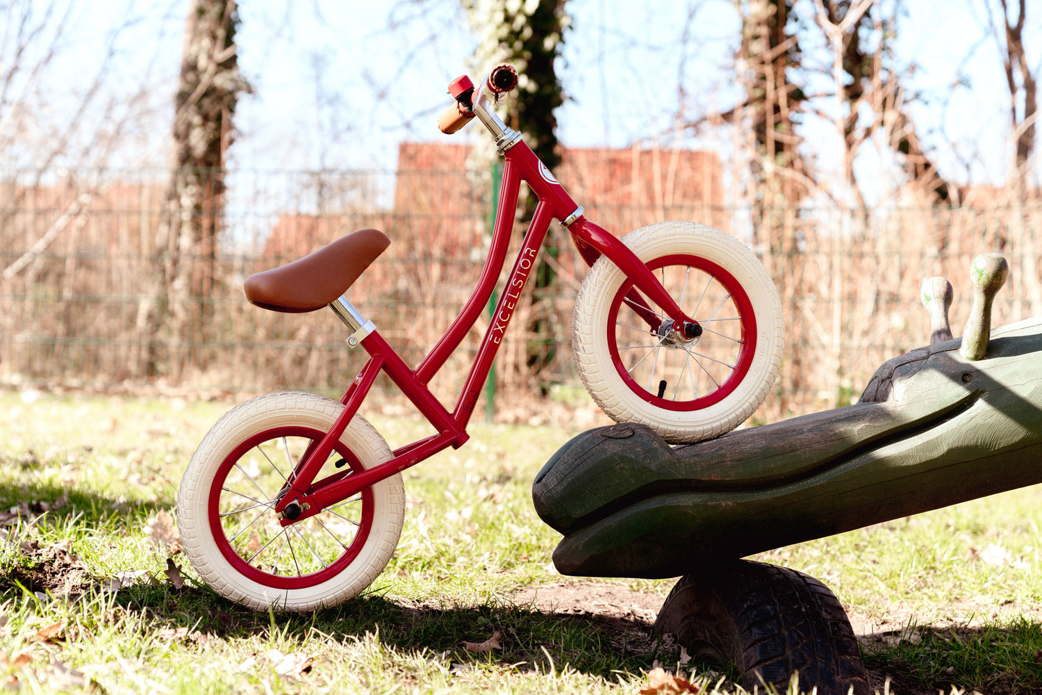 rotes Laufrad steht mit dem Vorderrad auf einer Holzwippe