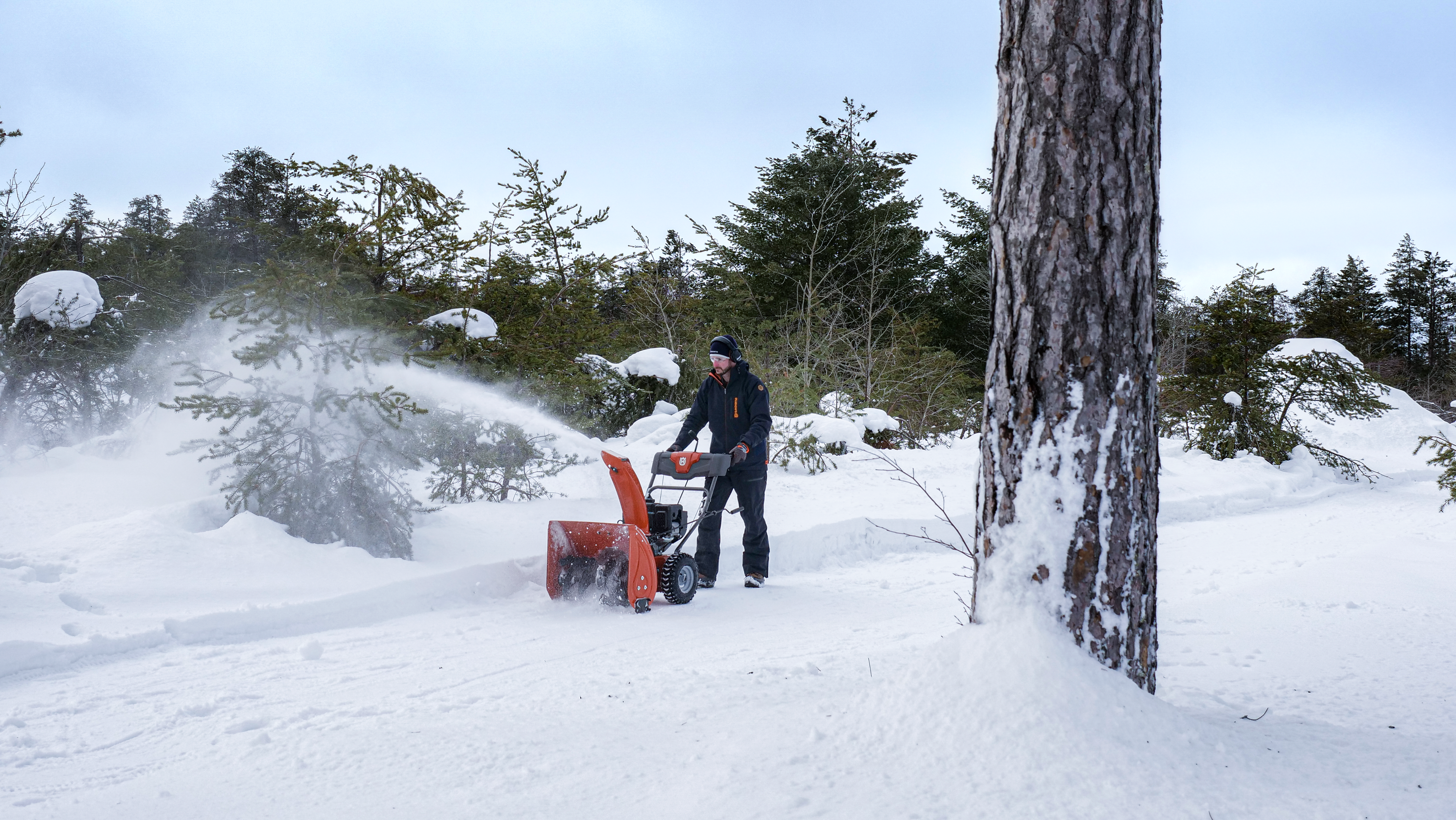 Mann erarbeitet einen Weg mit einer Schneefräse